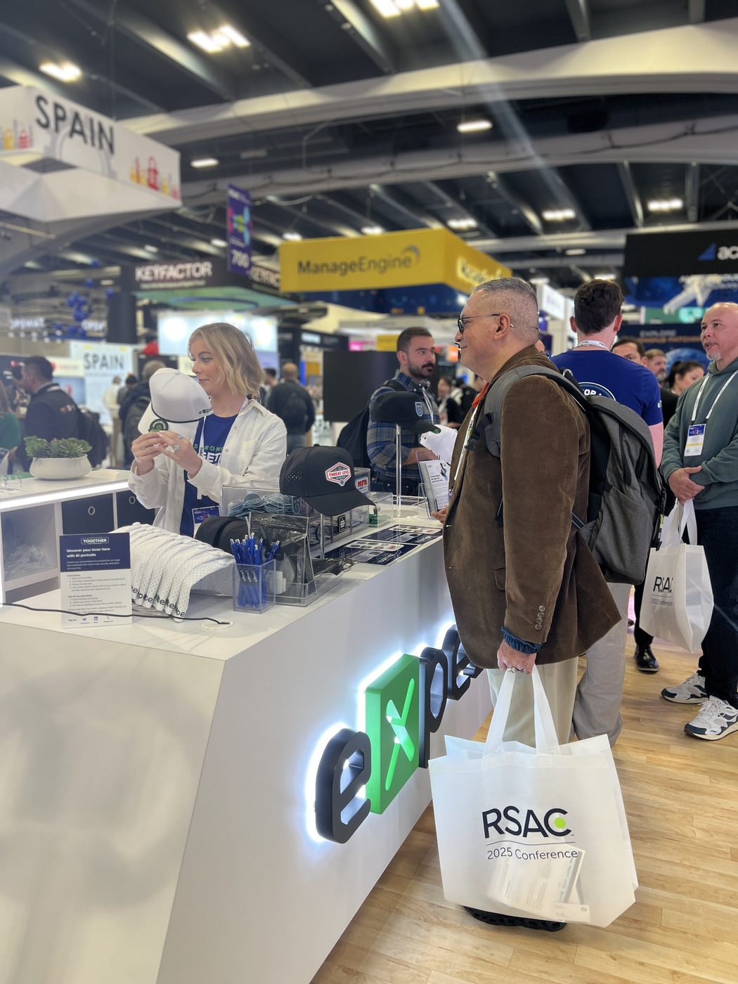 Attendees at the Expel counter where staff press patches onto hats